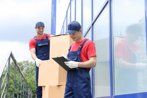 Removalists handling bulky furniture in a South London residential block